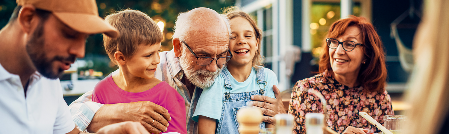 Elderly man hugging children outside